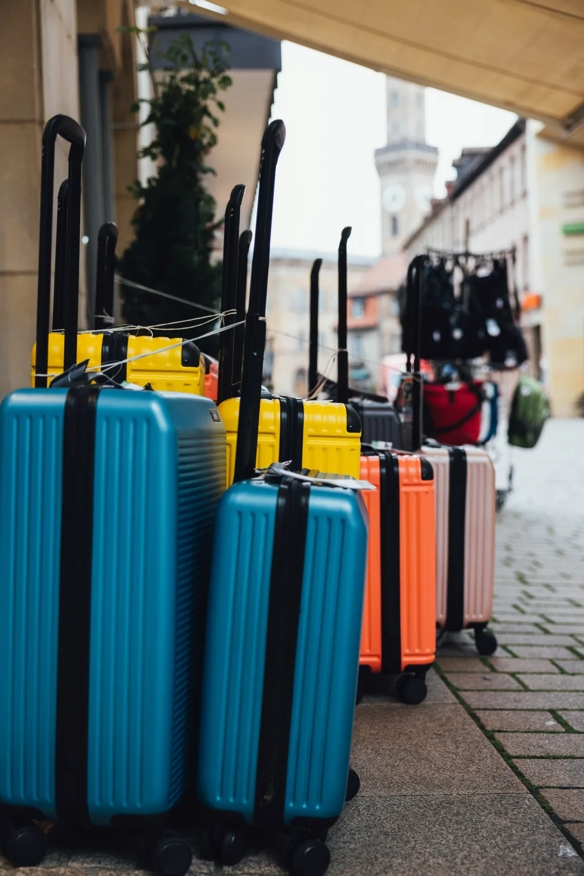 Colourful suitcases lined up on a sidewalk